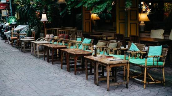 Empty outdoor café tables on a quiet street in Thailand